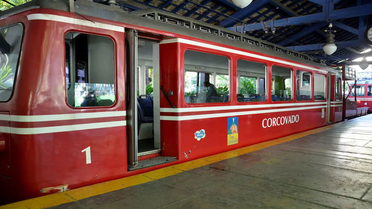 Tren del Corcovado de color rojo subiendo por las vías a través de la densa vegetación del Parque Nacional de la Tijuca.